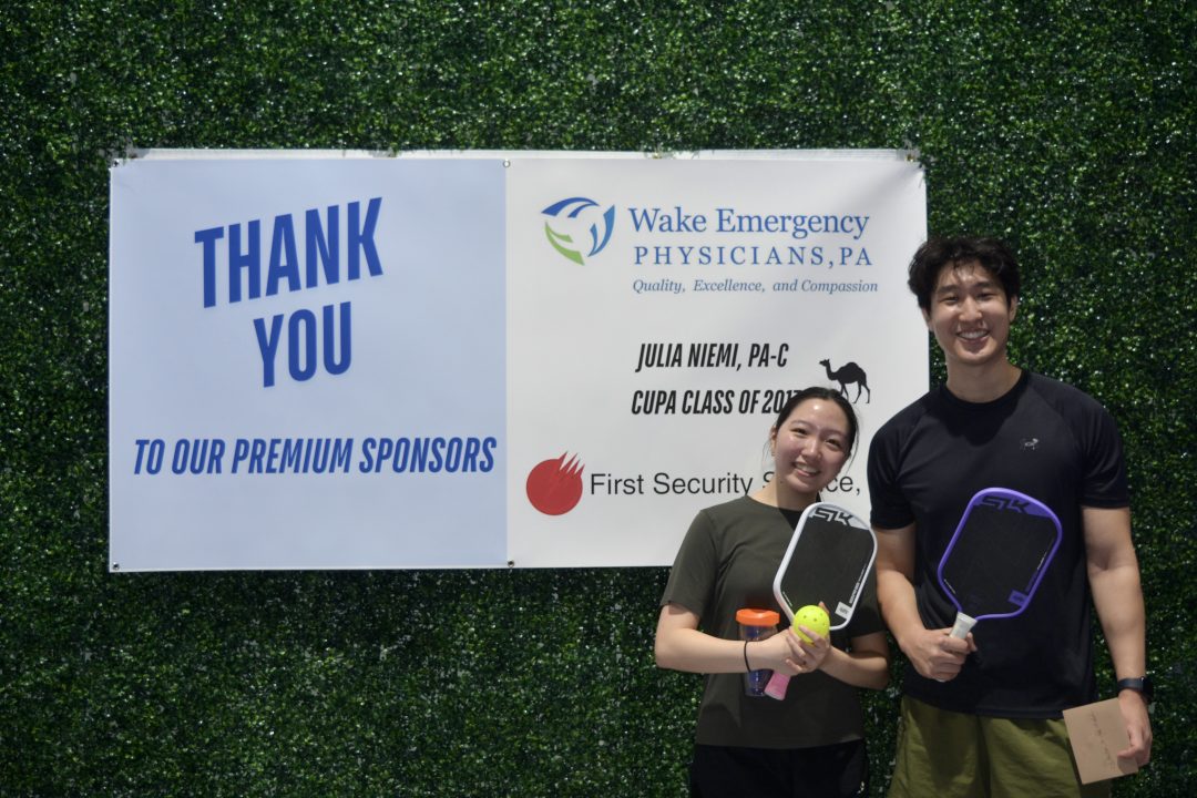 Co-ed winners male and female teammates standing with thank you sign