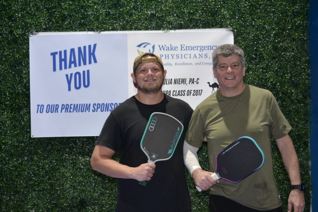 Male team winners standing with thank you sign