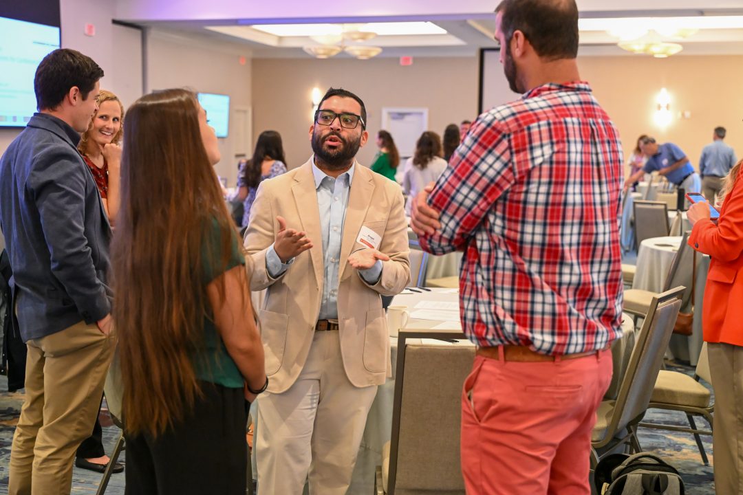 Group talking during break at continuing education symposium.