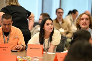 Incoming pharmacy students look up at screen in a classroom while working on an interactive game.