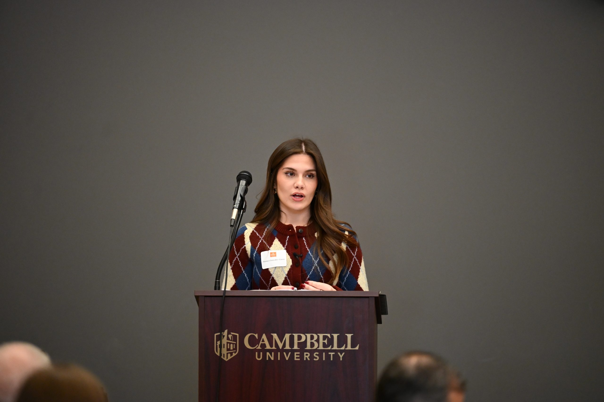 Nursing student at podium speaking to attendees