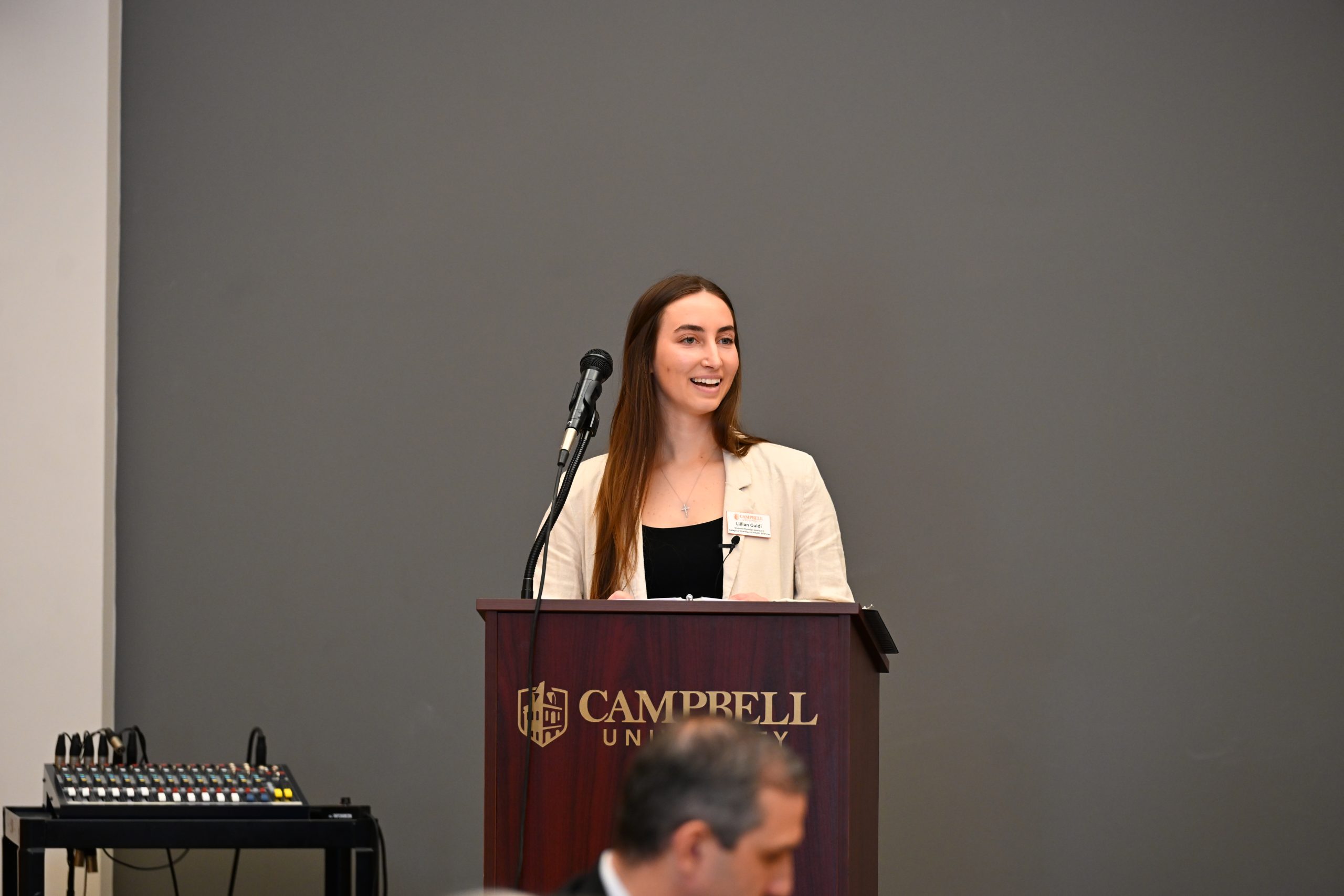 Scholarship recipient at podium addressing group