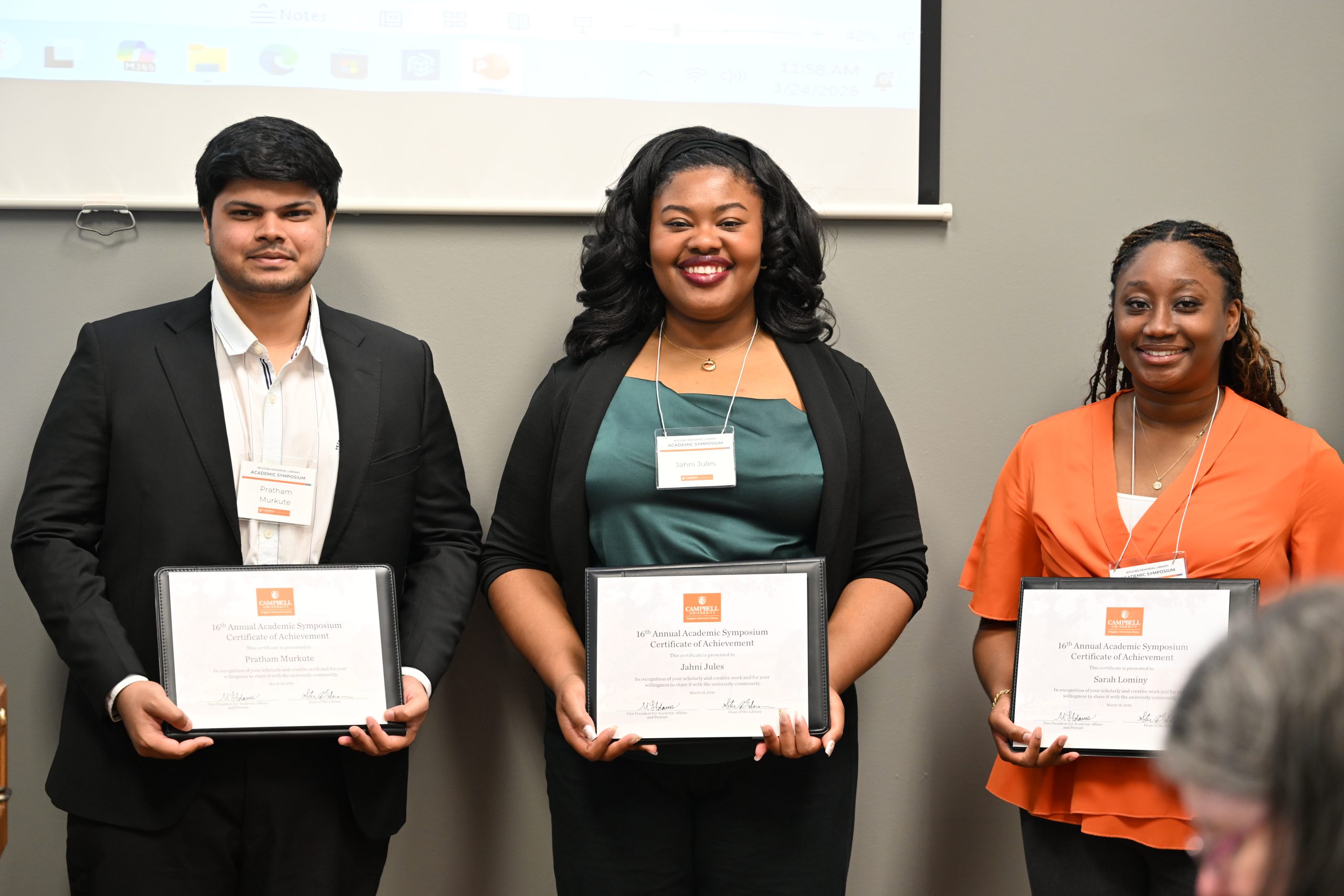 Three students standing together holding certificates