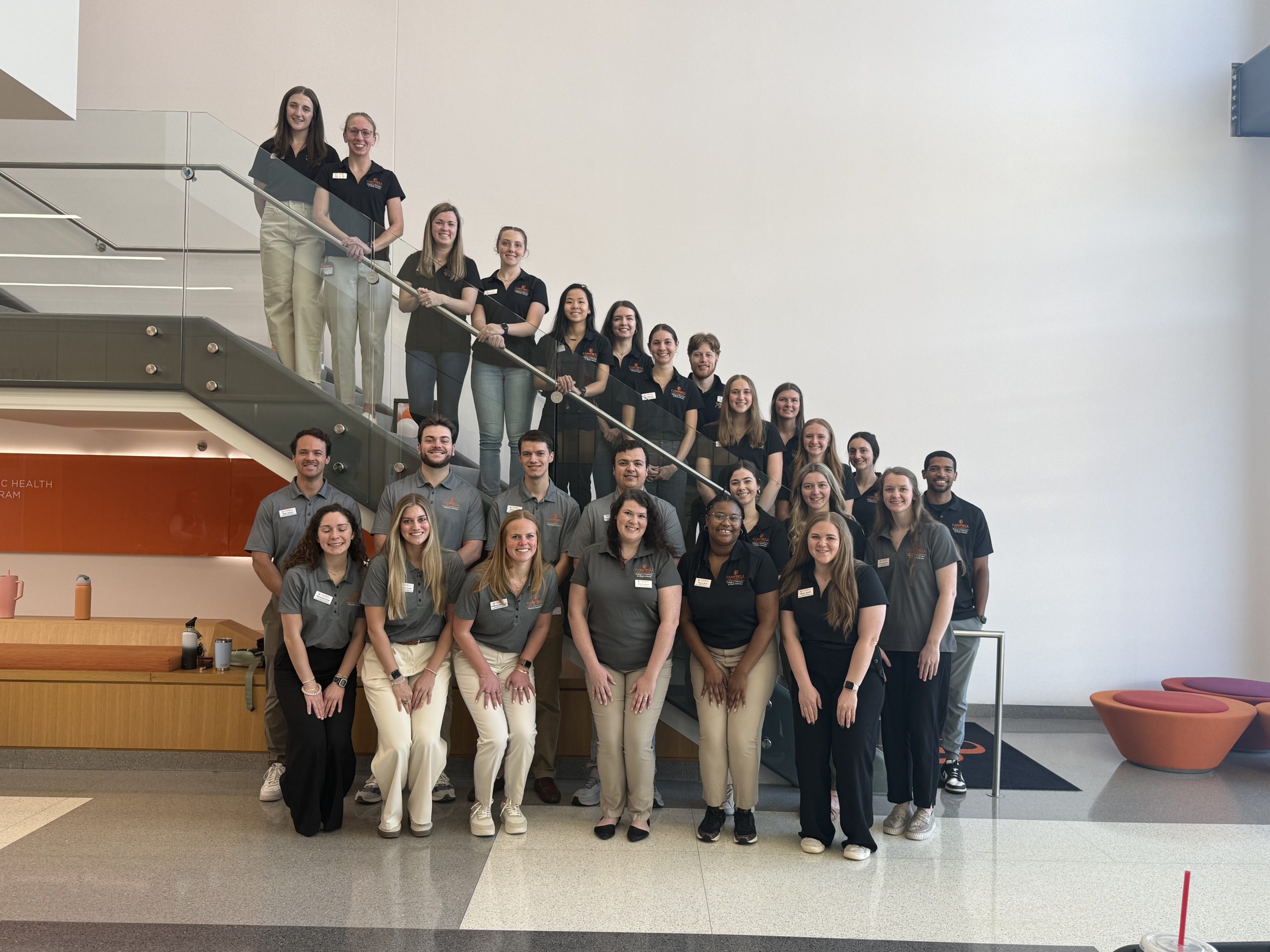 Student ambassadors gathered together on the lobby staircase smiling for the camera.