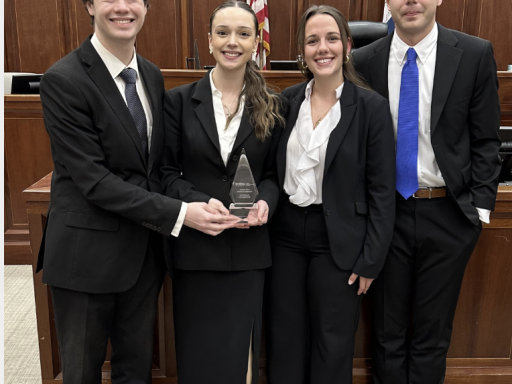 Photo of four Campbell Law advocates holding AAJ STAC national championship trophy in courtroom in New Orleans