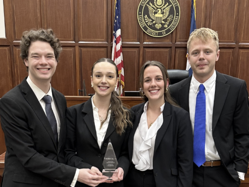 Photo of four Campbell Law advocates holding AAJ STAC national championship trophy in courtroom in New Orleans