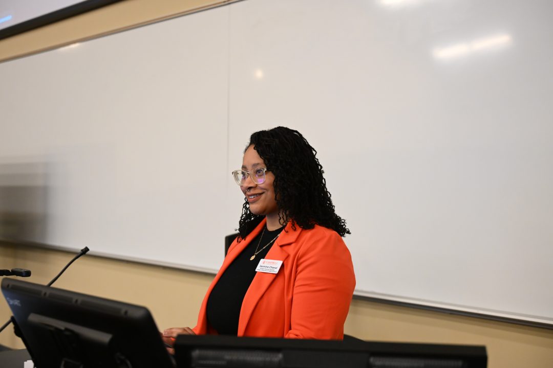 Female african-american student smiling at group standing at podium
