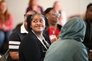 Incoming DPT student gazes up toward a screen in the classroom with a happy expression.