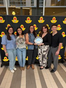 Photo of South Texas Campbell Law advocates and coach Sydney Kraft '25 holding awards