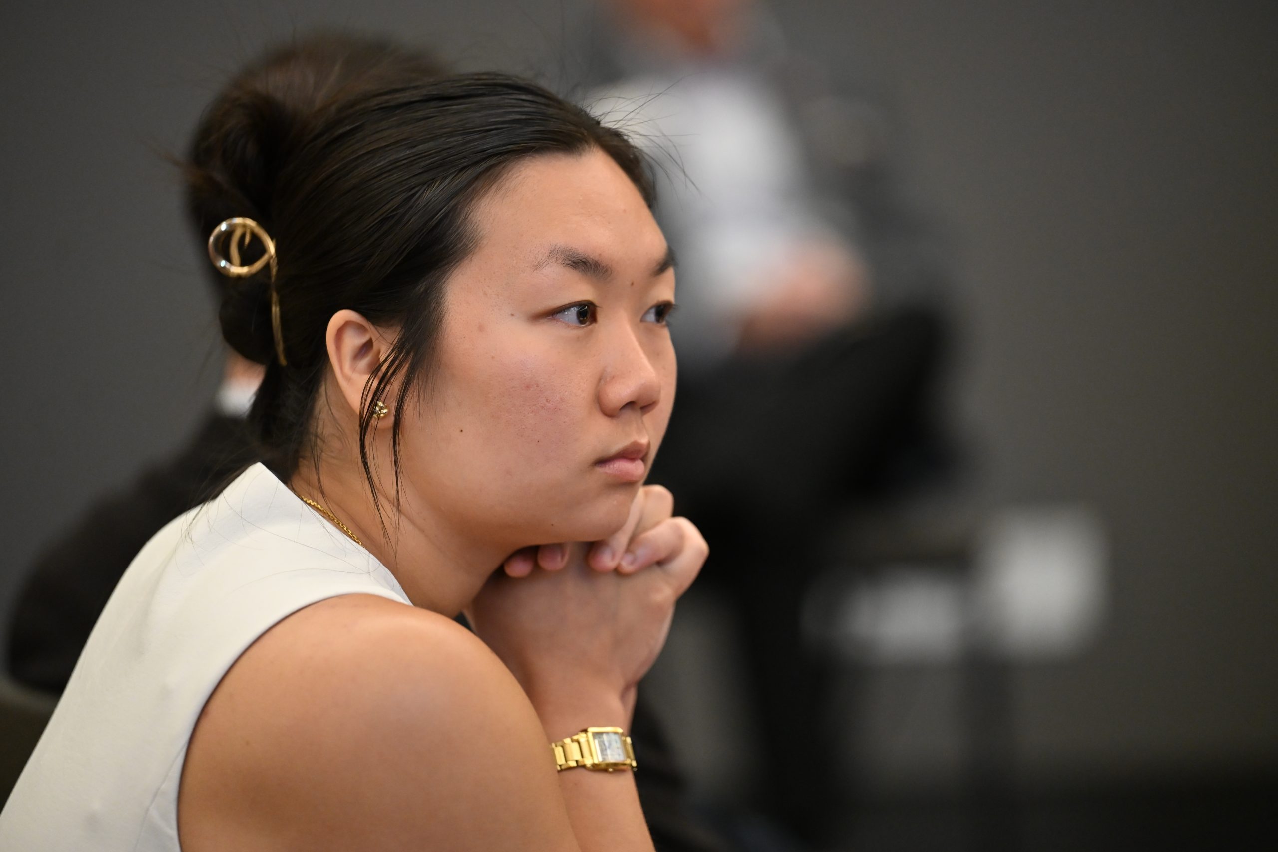 Asian female student watching the presentation with hair pulled up in a clip