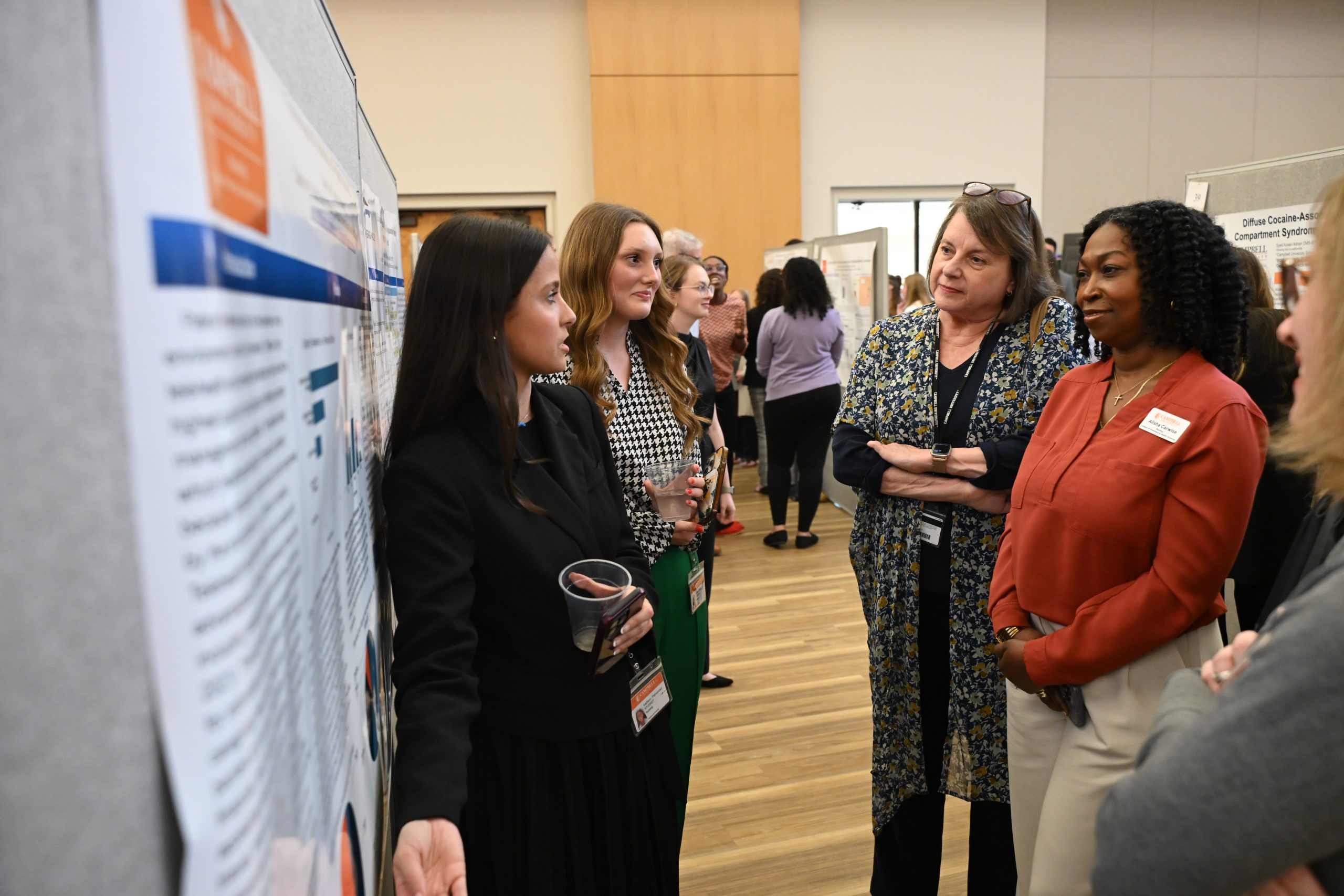 Nursing faculty members talking with poster presenters