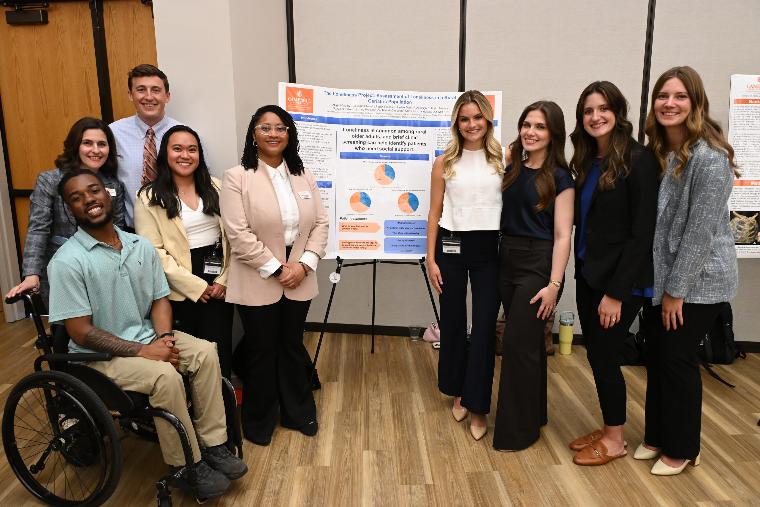 Group of male and female students standing with their poster