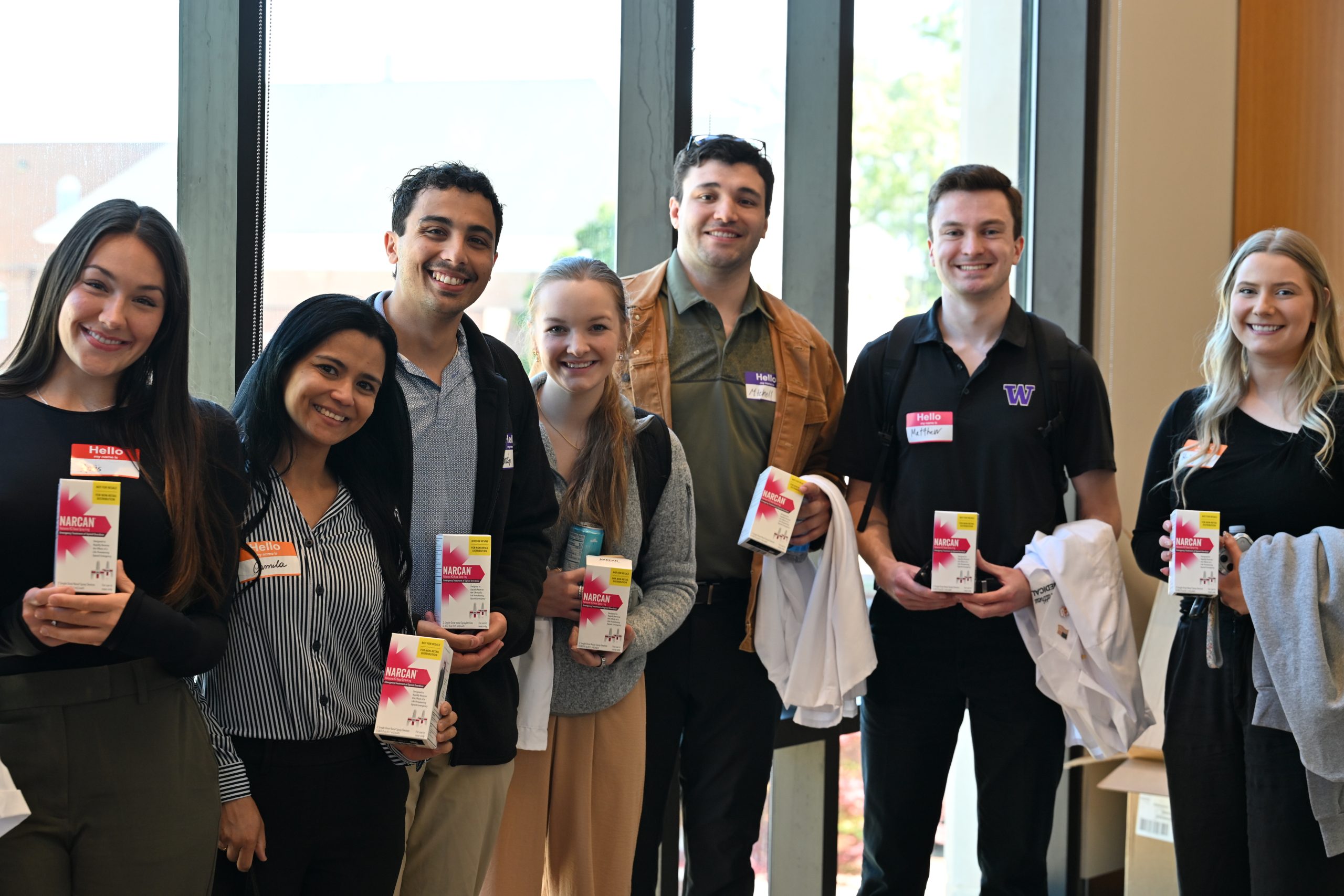 Group of male and female students holding narcan kits