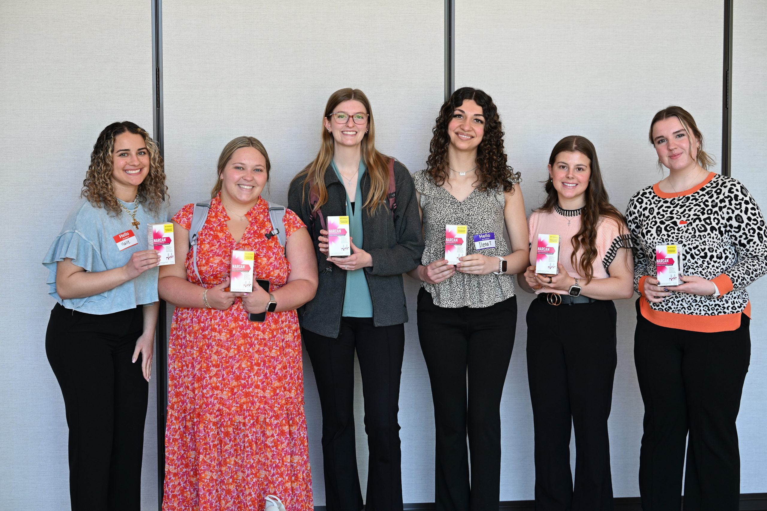 Female students standing together holding Narcan kits