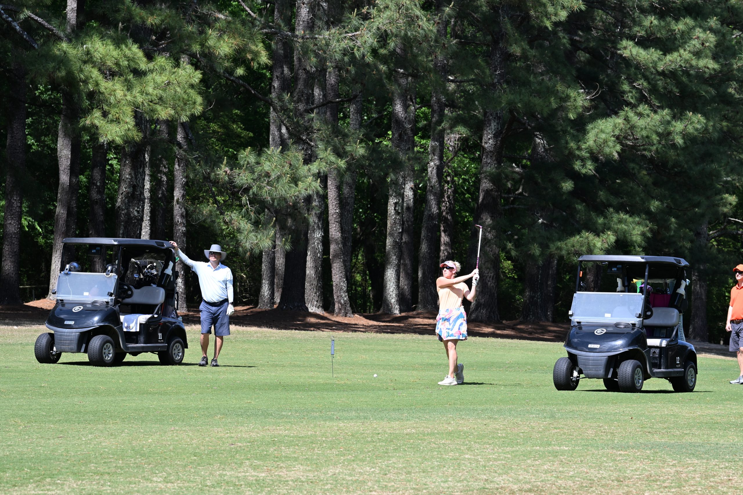 Female golfer hits a ball on the course