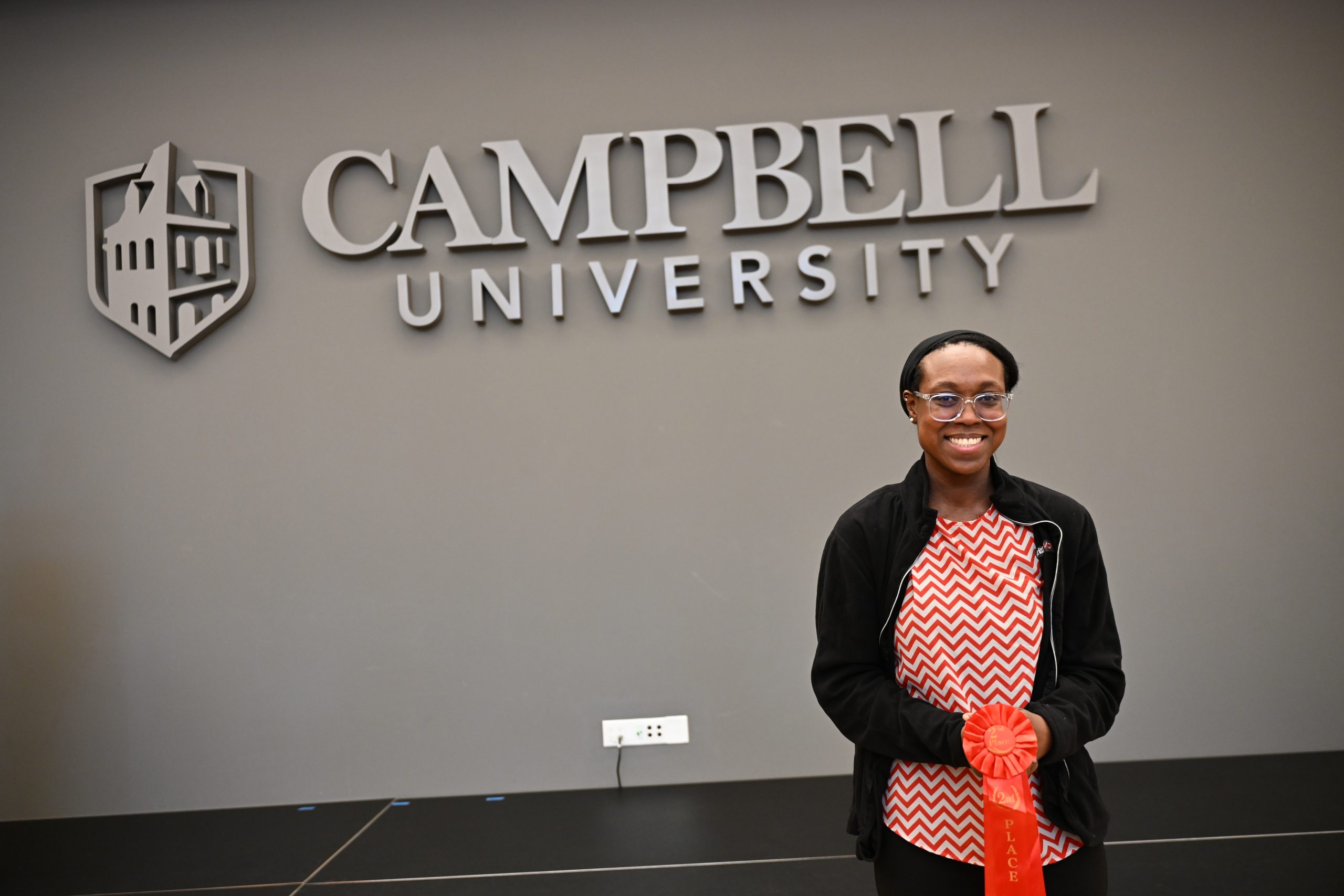 Female student holding red award ribbon