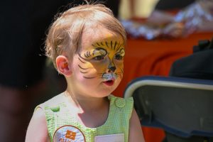 A child with a tiger facepaint.