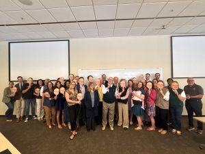 Photo of law school faculty and staff gathered around Professor Johnny Chriscoe after his last class