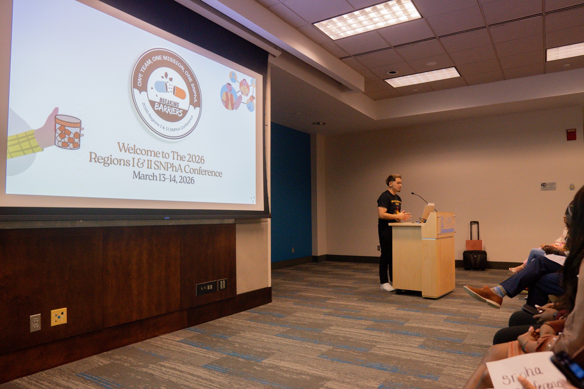 Male student speaking to students from podium.
