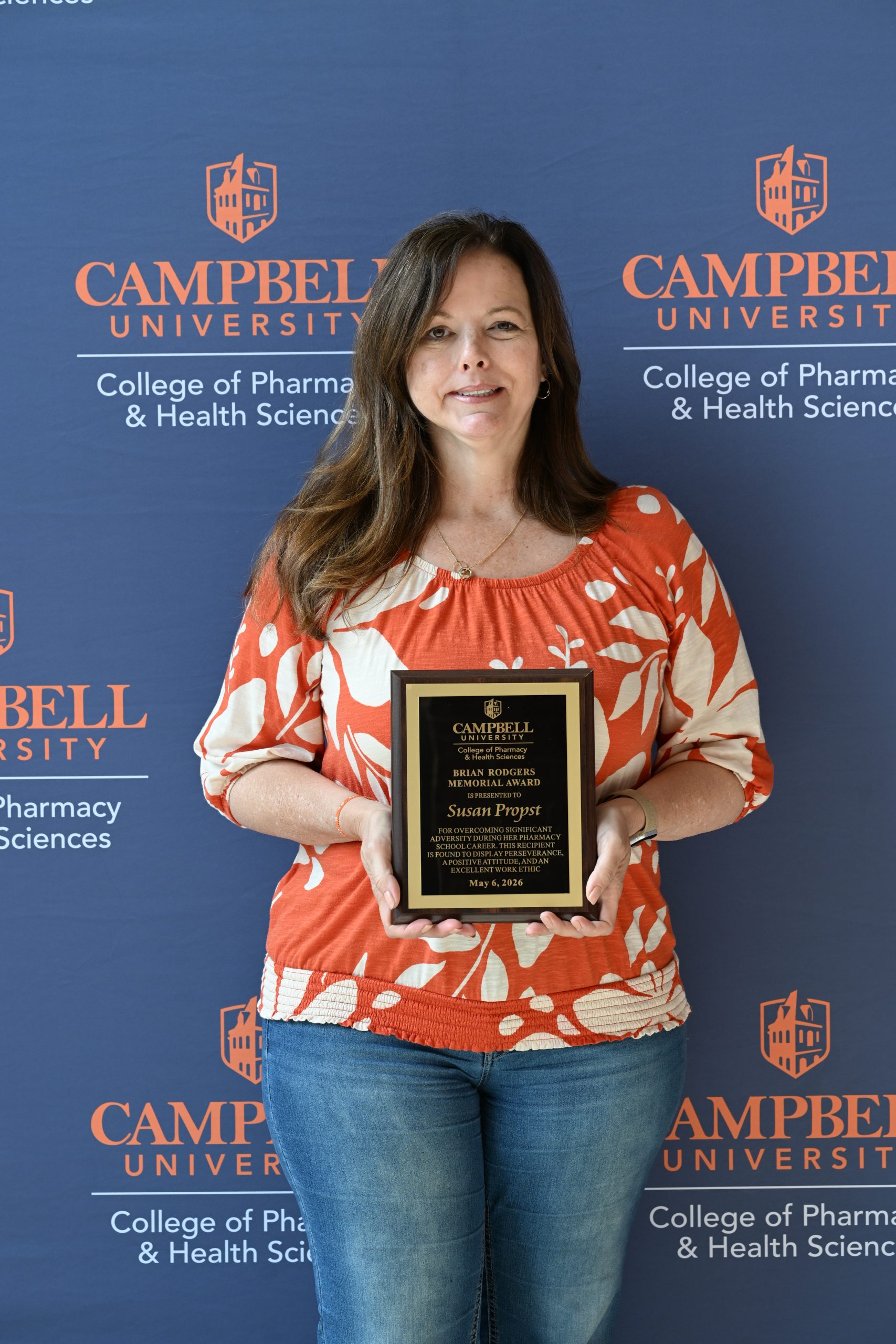 Female holding award plaque.