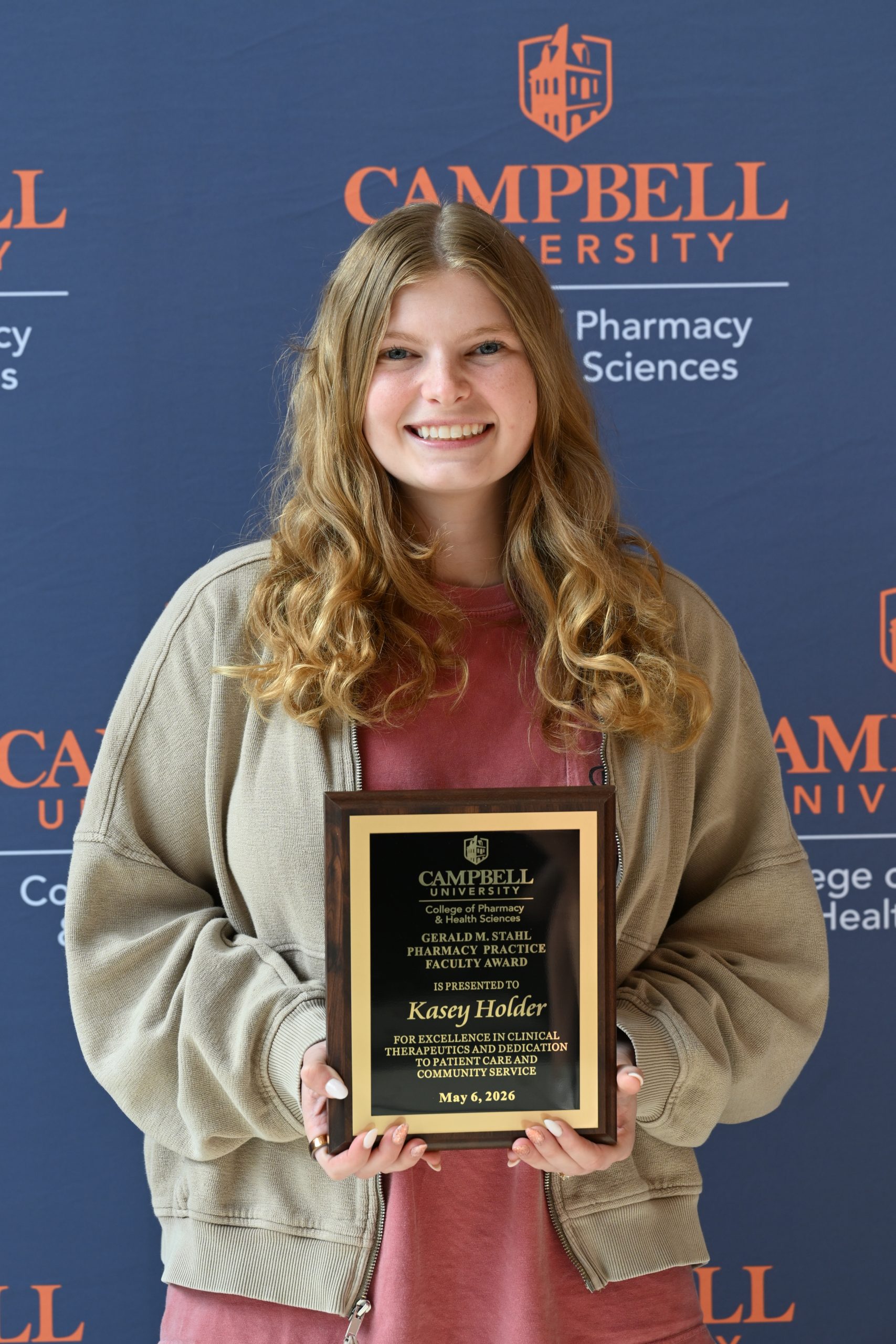 Female holding awards plaque.