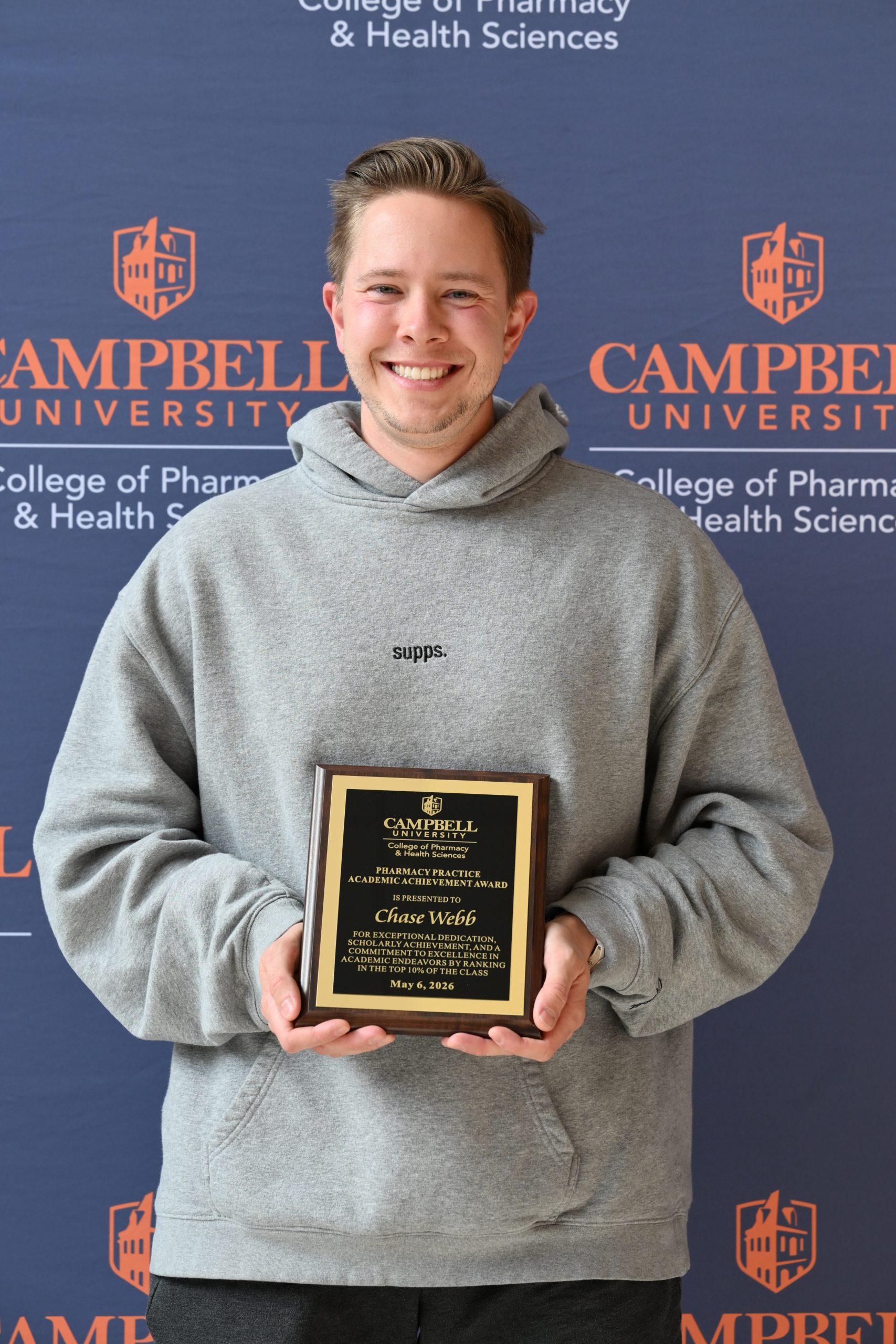 Male holding awards plaque.