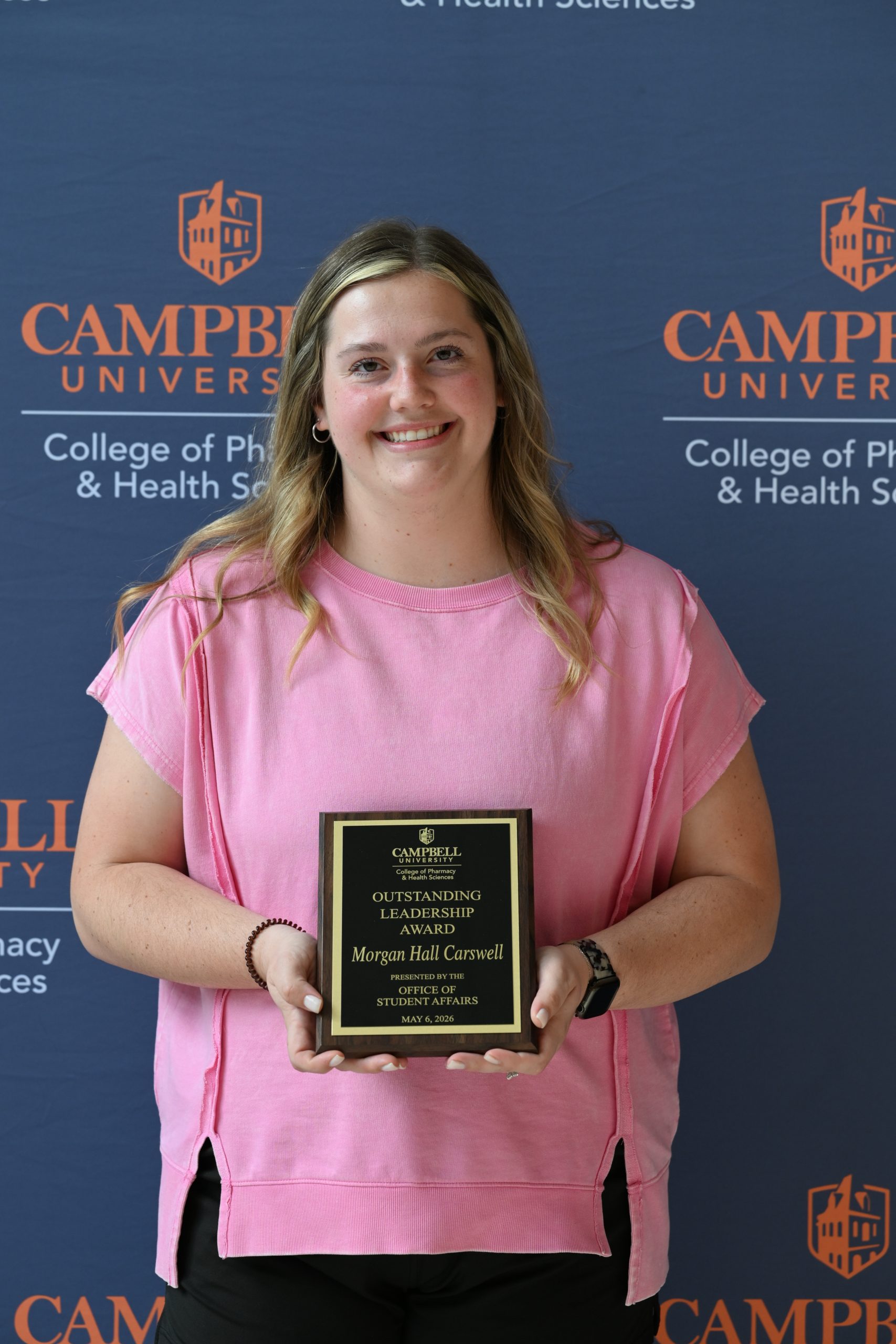 Female holding awards plaque.