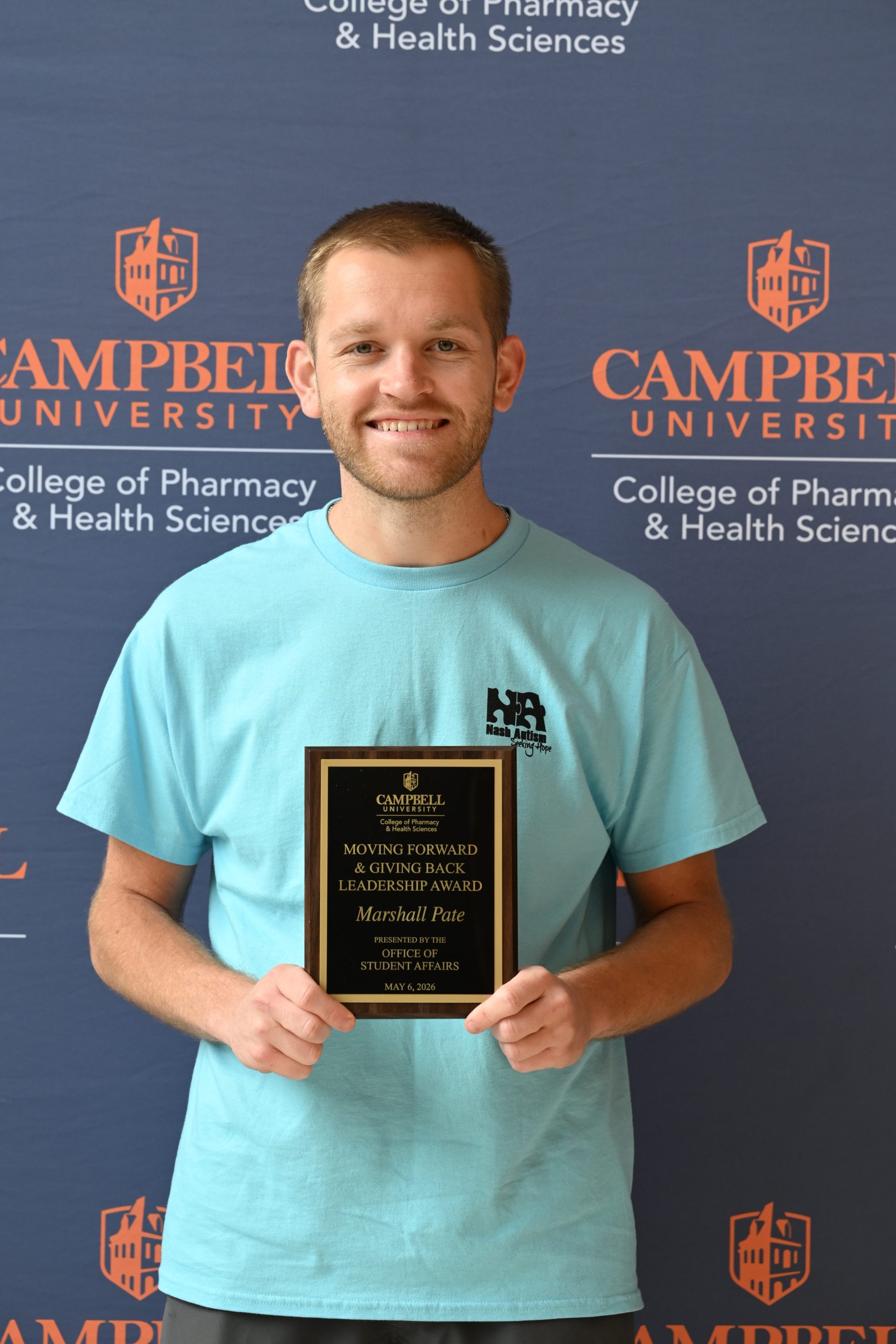 Male holding awards plaque.