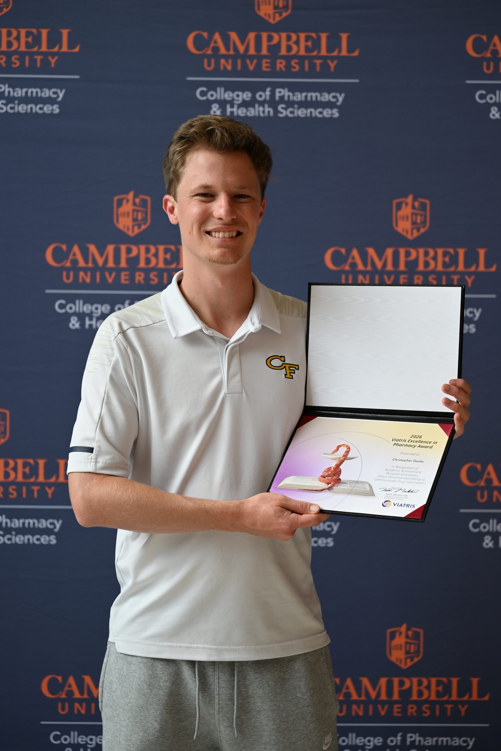 Male student holding certificate