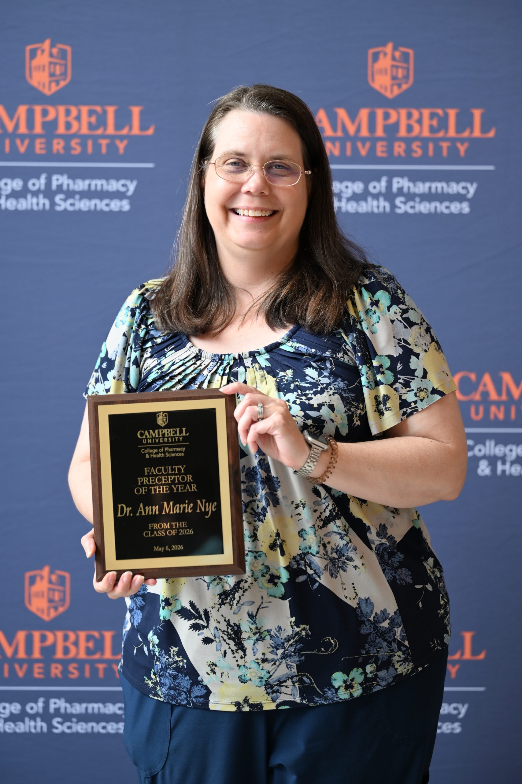 Female holding award plaque.
