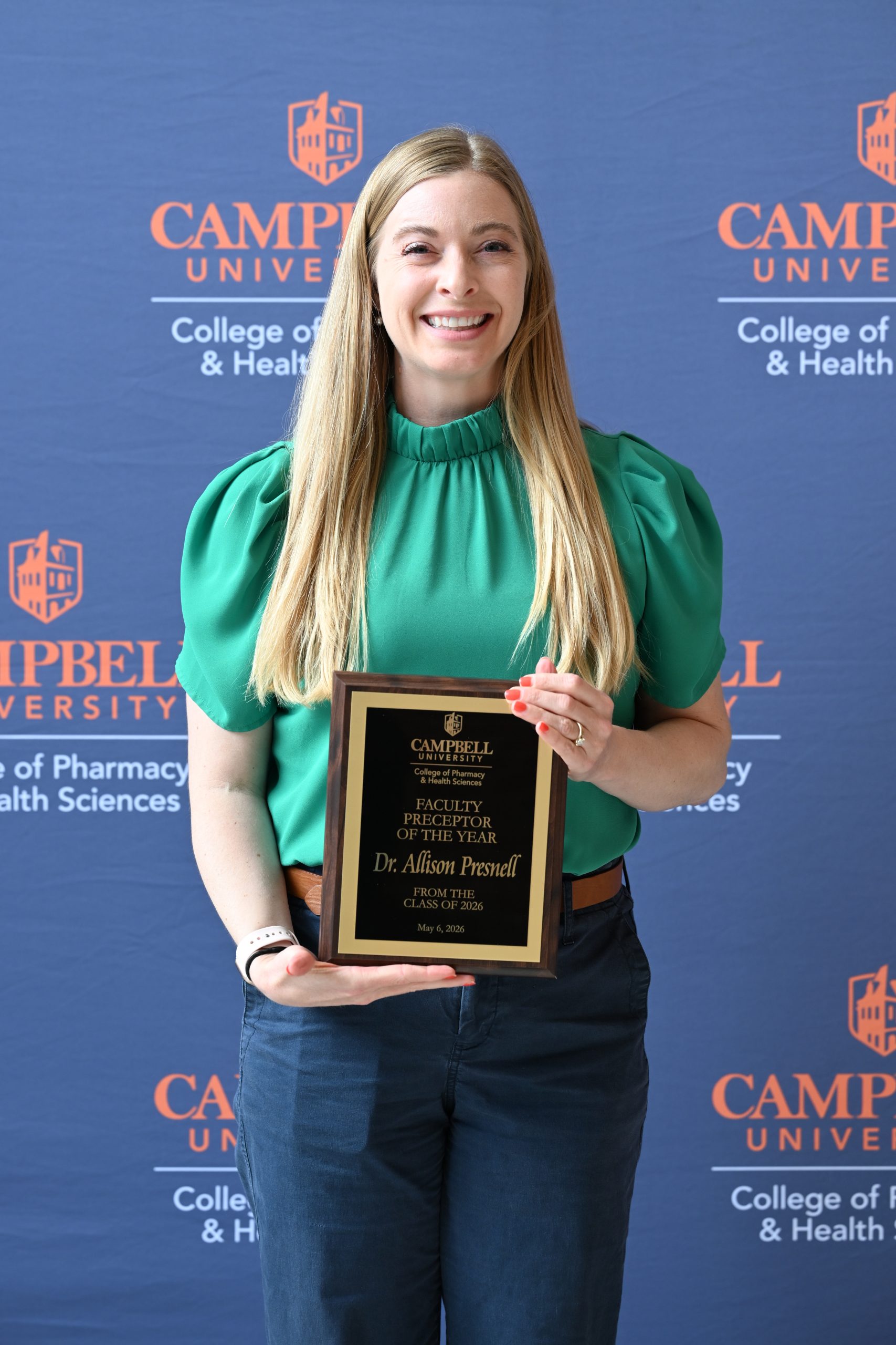 Female holding award plaque.