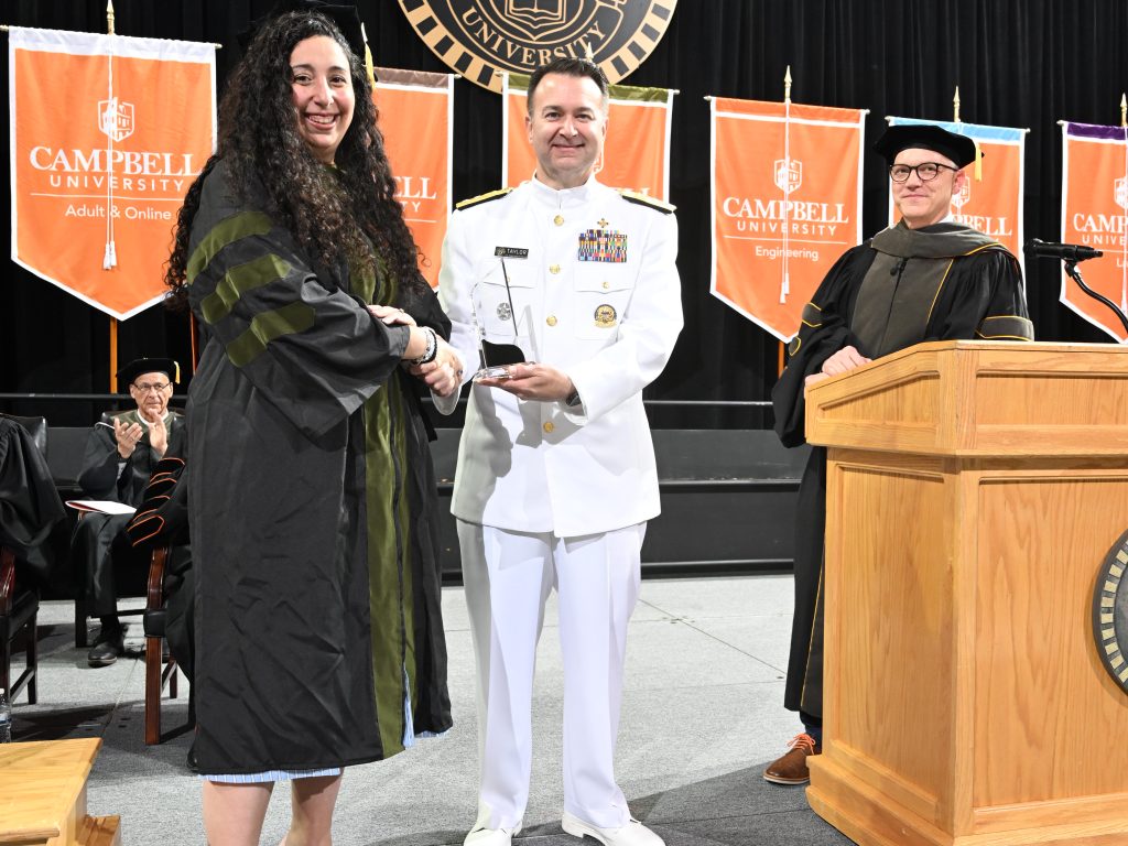 Dr. Eliana Wood hands award to Dr. Brandon Taylor