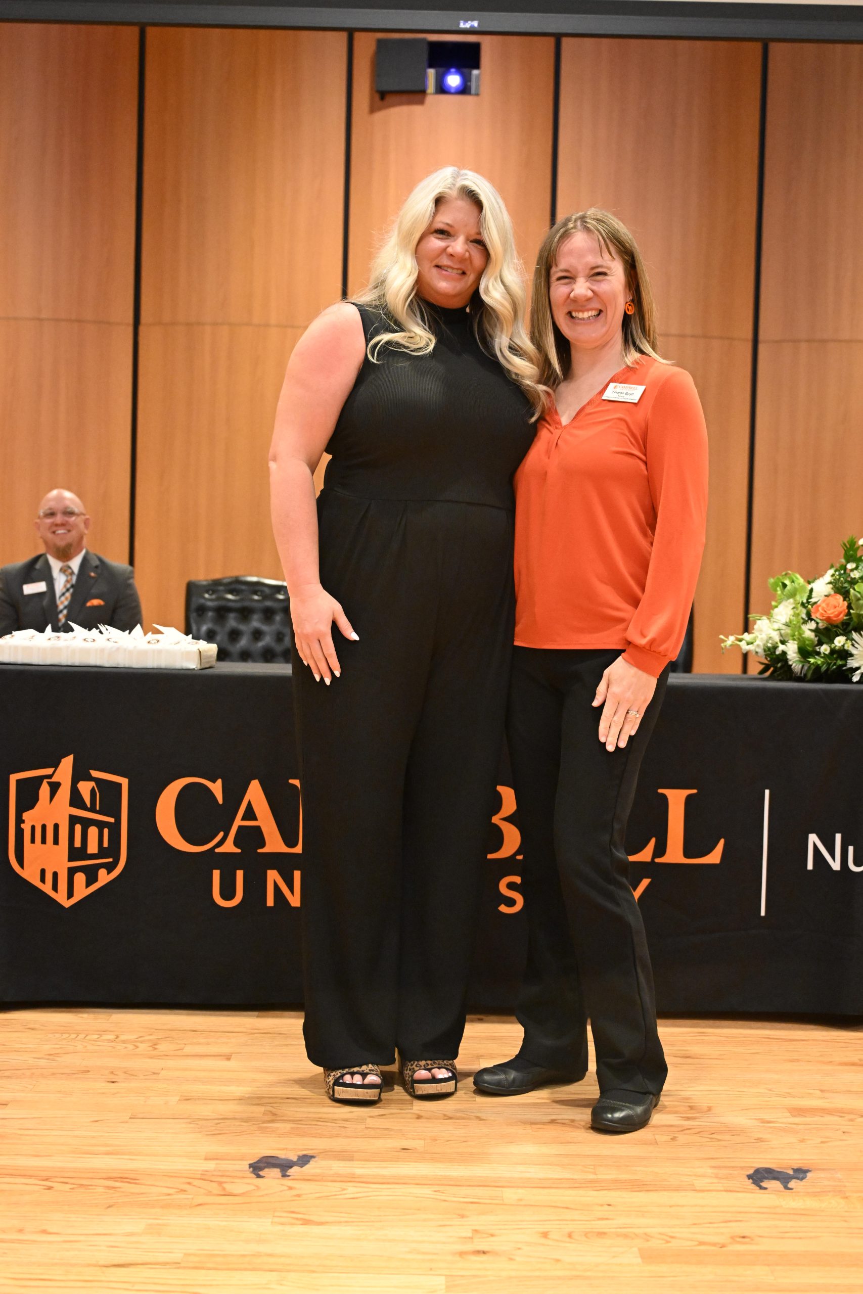 Two female faculty members standing together.