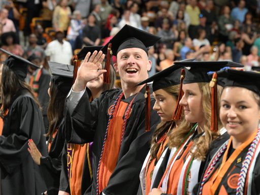 Male nursing student waves to loved ones