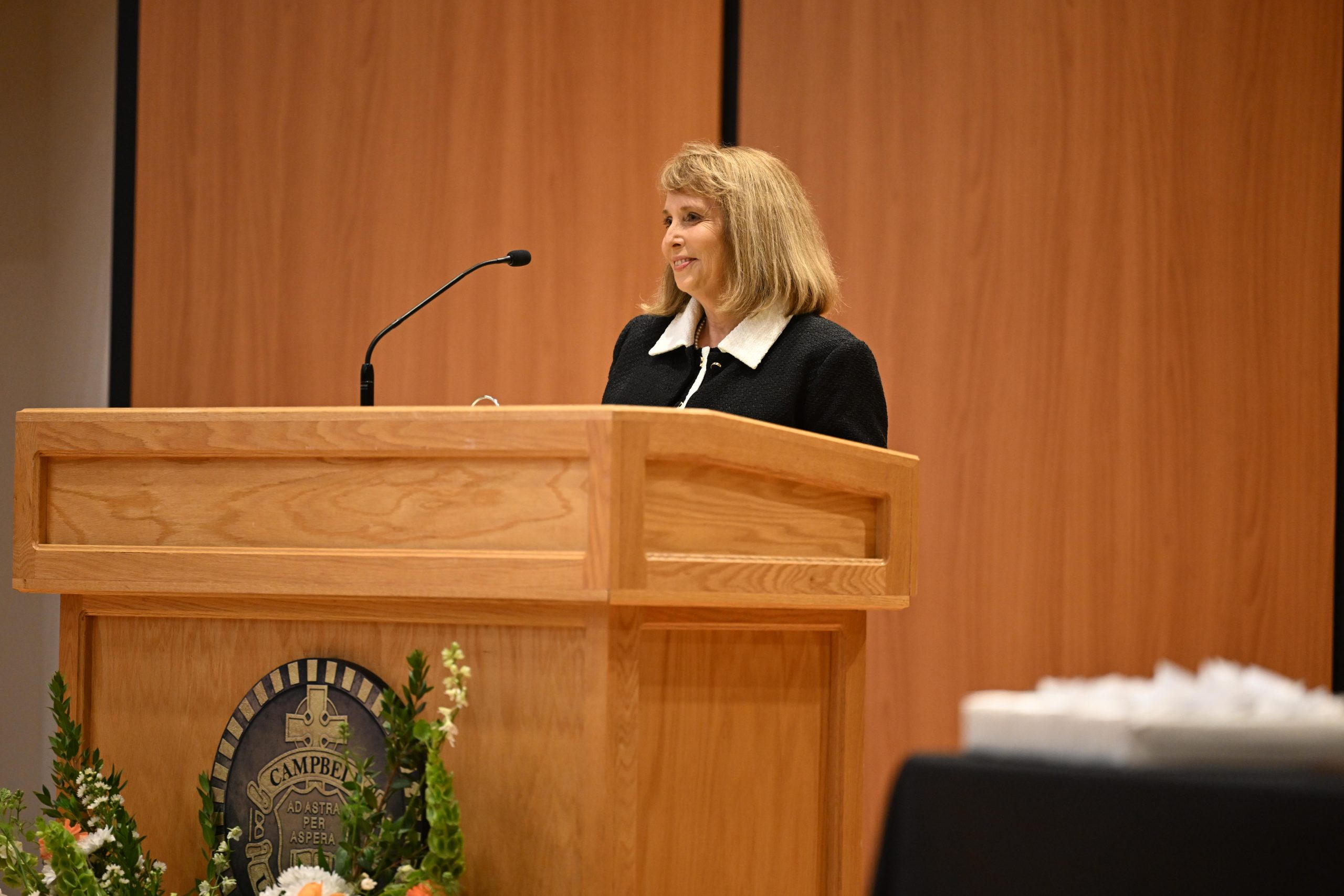 Female wearing black suite speaking at podium
