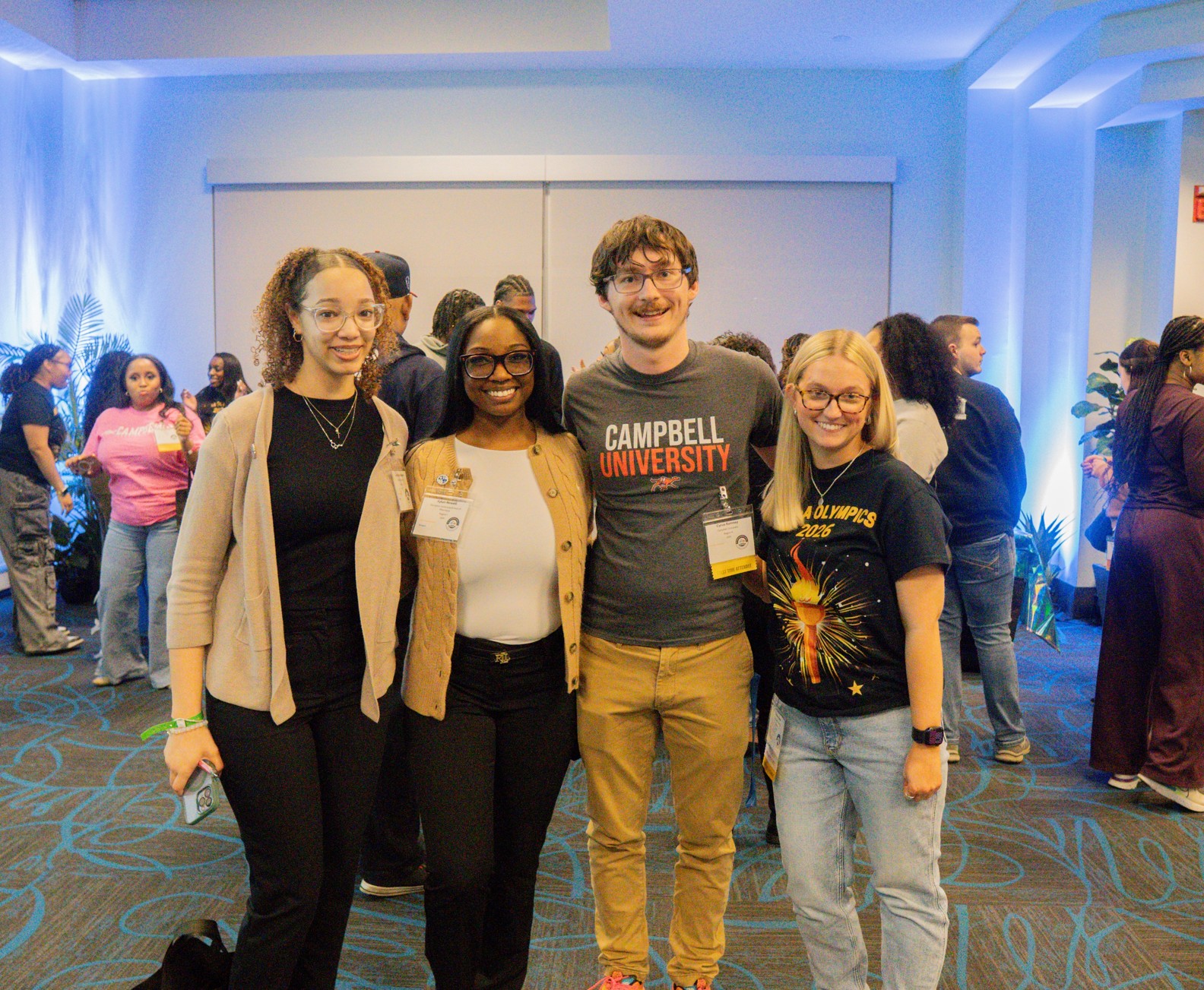 Three female students and one male student standing together for a photo.