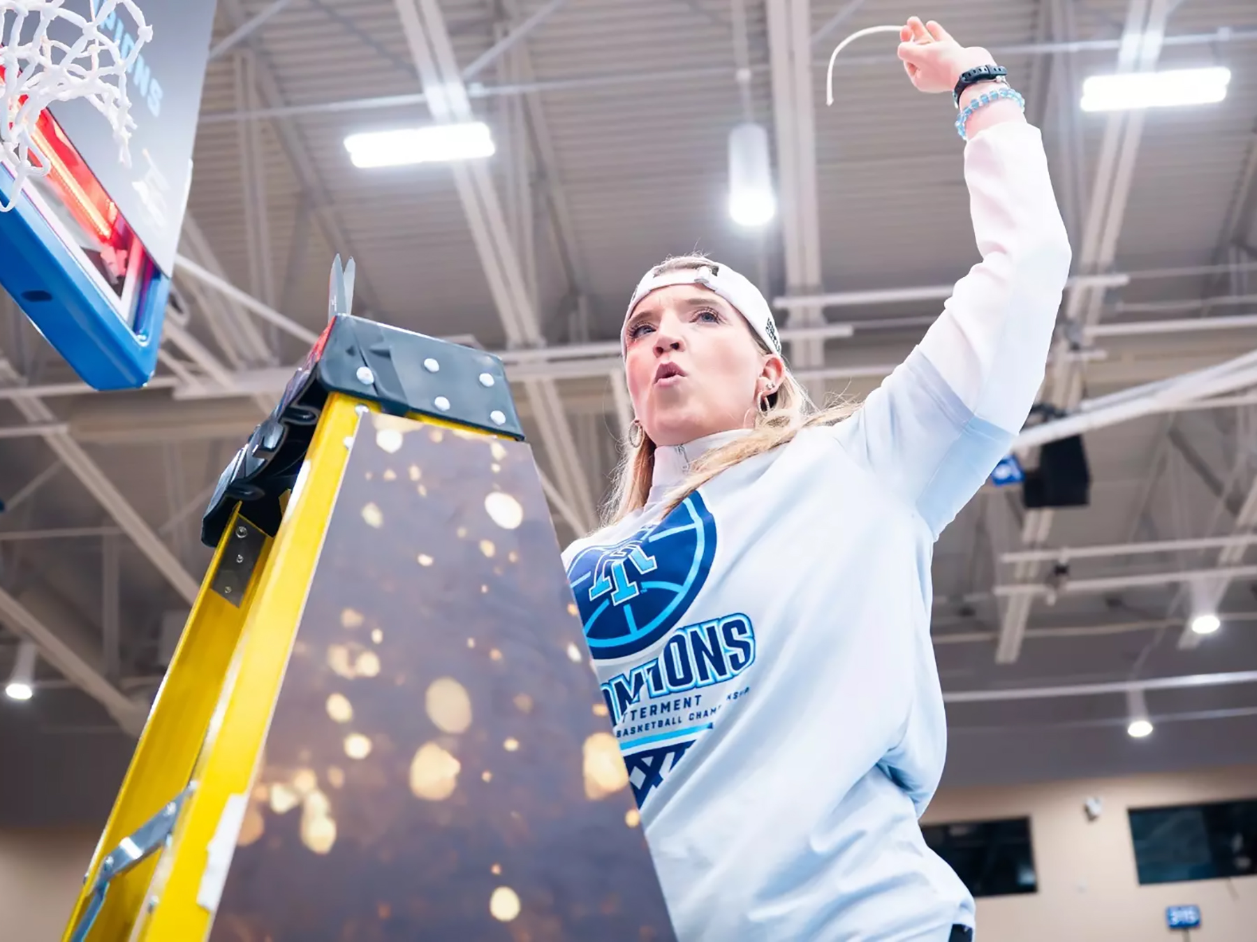 Ali Jaques cuts down the net at the University of Rhode Island