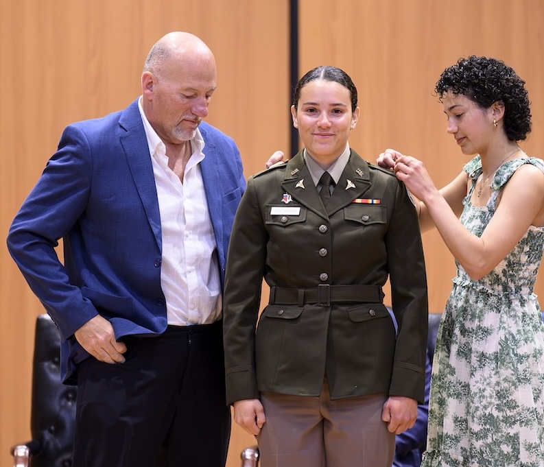 Photo of pinning of new Army caption during CUSOM commissioning ceremony