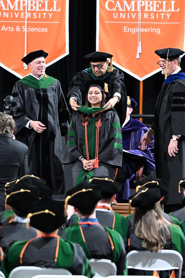 Photo of a hooding of CUSOM graduate