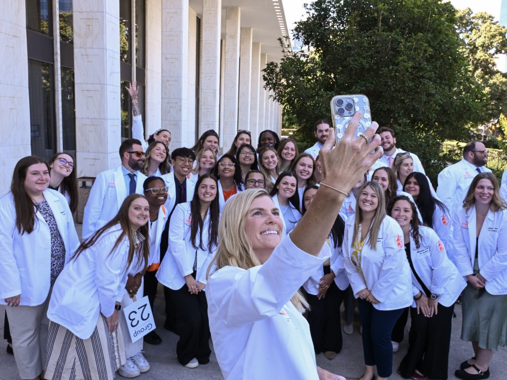 female holds phone for selfie photo of group of PA students