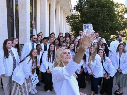 female holds phone for selfie photo of group of PA students