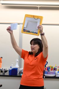 Female faculty holds up example in lab