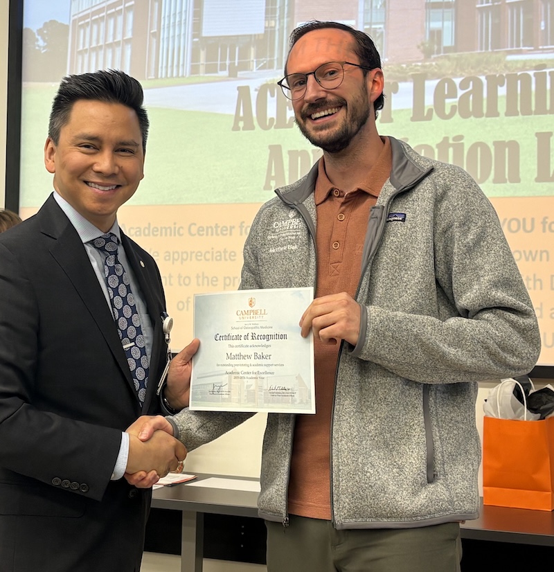 Dr. Tolentino poses with a student holding Peer Learning Partner award.