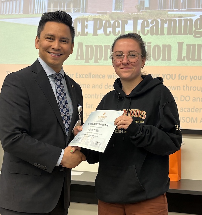 Dr. Tolentino poses with a student holding Peer Learning Partner award.