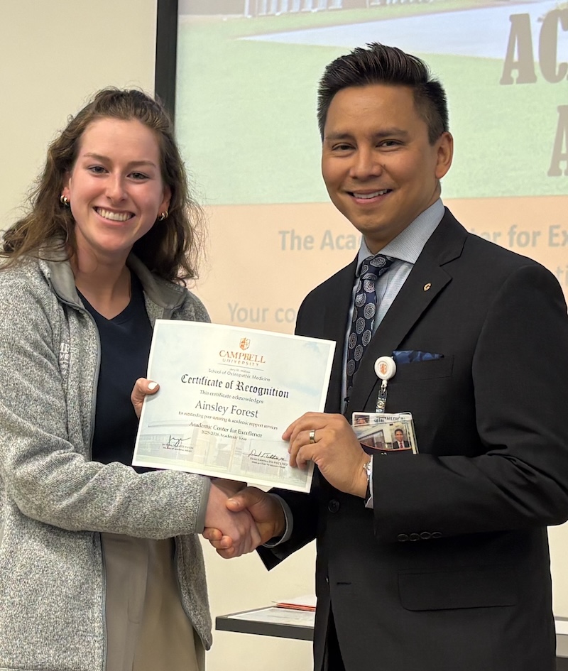 Dr. Tolentino poses with a student holding Peer Learning Partner award.
