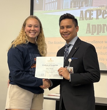 Dr. Tolentino poses with a student holding Peer Learning Partner award.