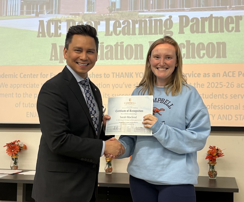 Dr. Tolentino poses with a student holding Peer Learning Partner award.