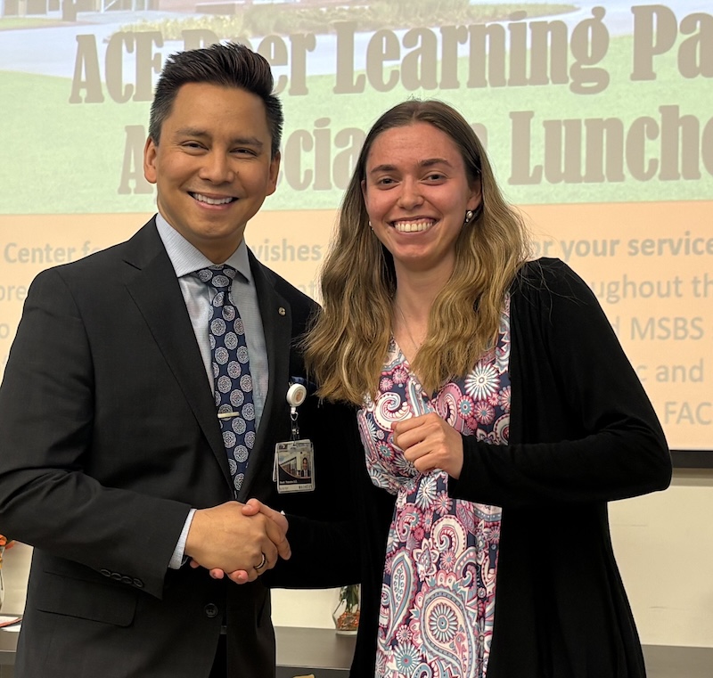 Dr. Tolentino poses with a student holding Peer Learning Partner award.
