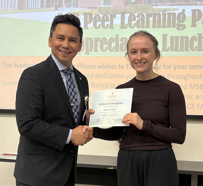 Dr. Tolentino poses with a student holding Peer Learning Partner award.