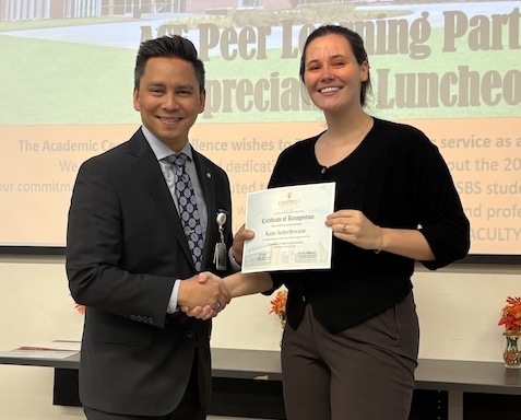 Dr. Tolentino poses with a student holding Peer Learning Partner award.
